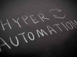 Handwriting of HYPER AUTOMATION in white colour by chalk on rough blackboad.